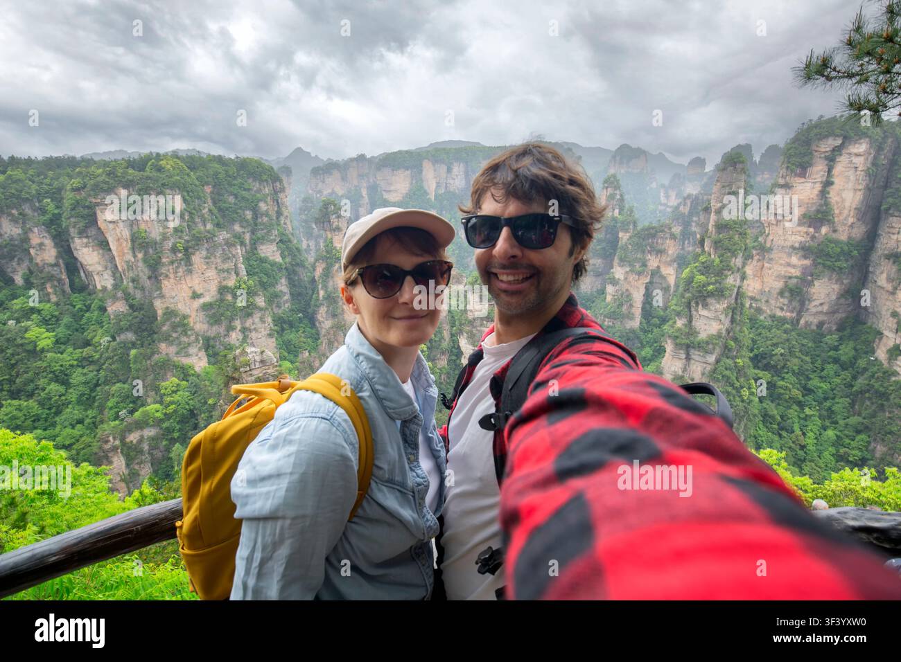 Una coppia di viaggiatori sta facendo un selfie con la vista sullo sfondo della scogliera calcarea di "Zhangjiajie". Qui c'è un incredibile punto di riferimento naturale della Cina. Foto Stock