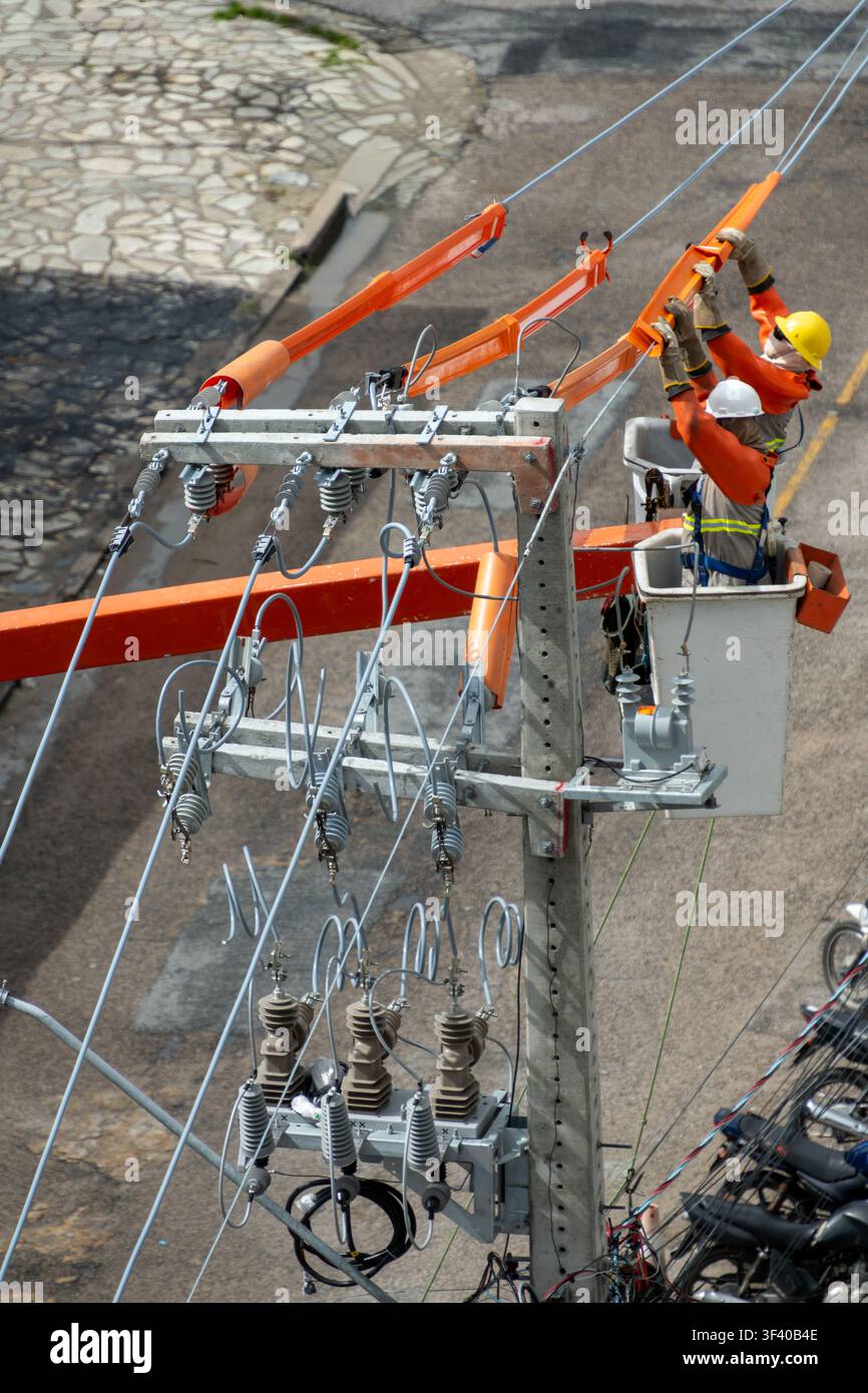 Lavoratori della rete elettrica che eseguono lavori di manutenzione su un palo di distribuzione dell'energia a João Pessoa, Paraíba, Brasile il 16 luglio 2026 Foto Stock
