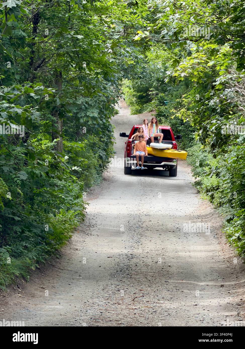 Bambini che viaggiano sul retro di un pickup in estate su una strada sterrata a Orleans, Cape Cod, Massachusetts. Foto Stock