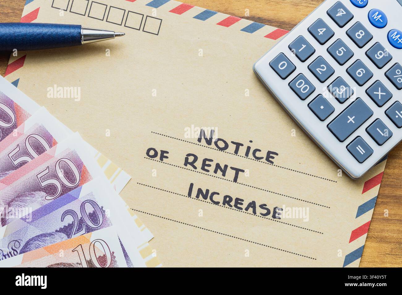 Concetto di avviso di aumento dell'affitto nel Regno Unito con testo sulla busta, banconote in sterline britanniche, calcolatrice e penna. Spese immobiliari, budget domestico a Foto Stock