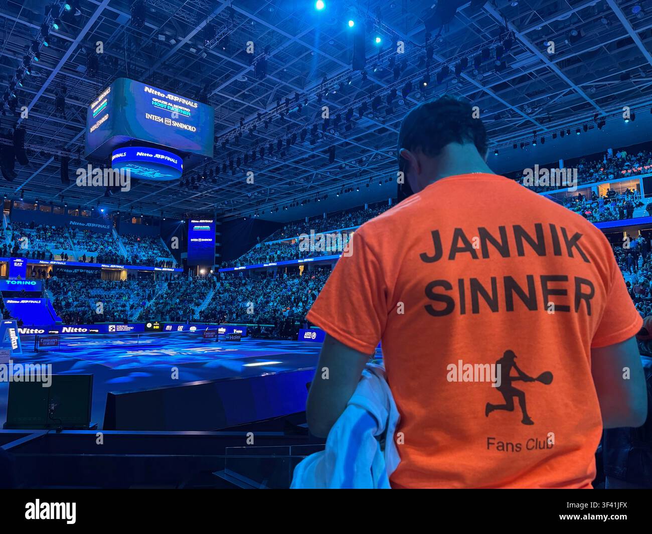 Un tifoso di tennis con una maglietta di Jannik Sinner osserva dalle tribune durante le Nitto ATP Finals a Torino, Italia. - Immagine stock catturata con smartphone