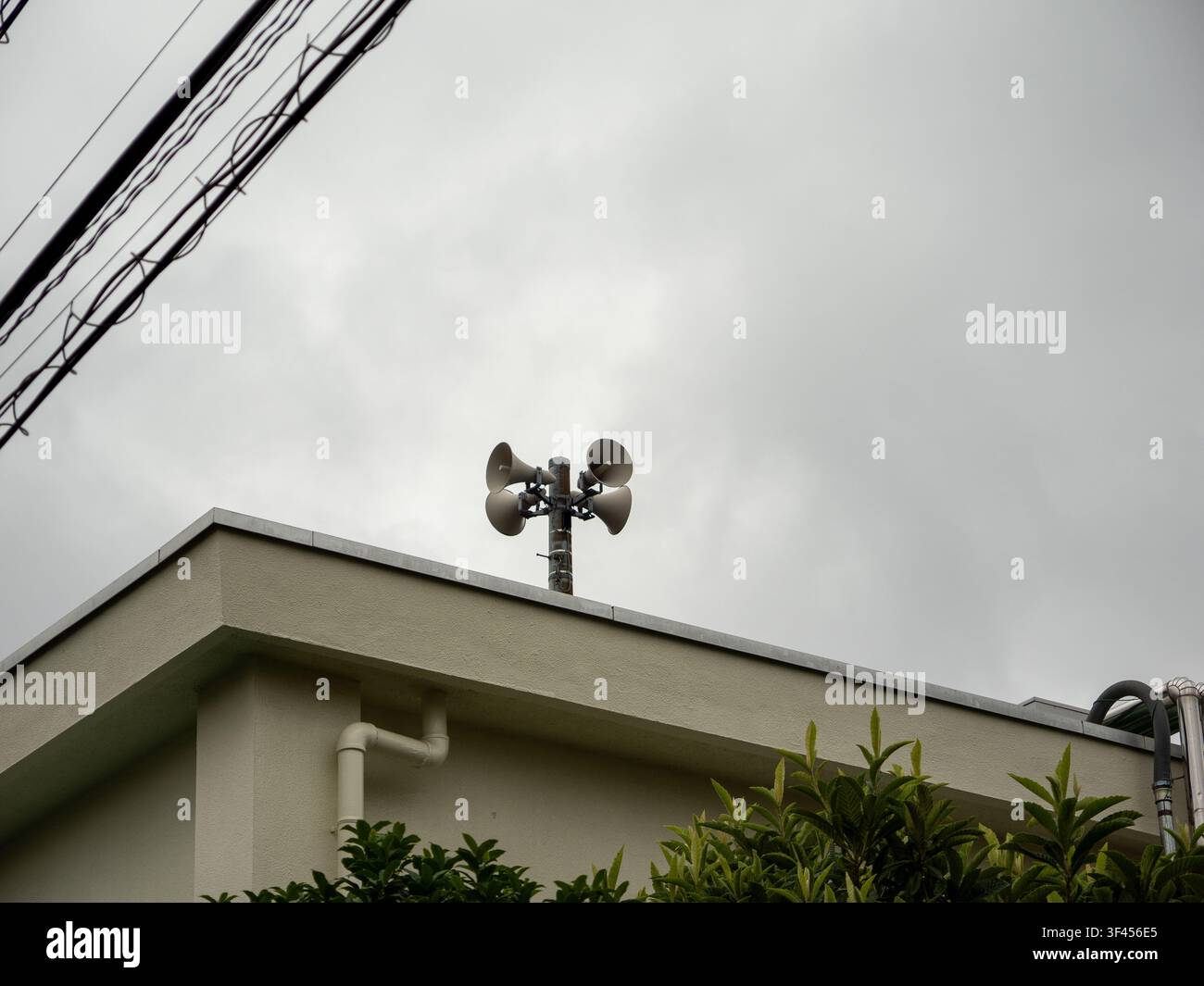 Altoparlanti di trasmissione di emergenza su un palo sul tetto sotto un cielo nuvoloso a Setagaya, Tokyo, Giappone Foto Stock