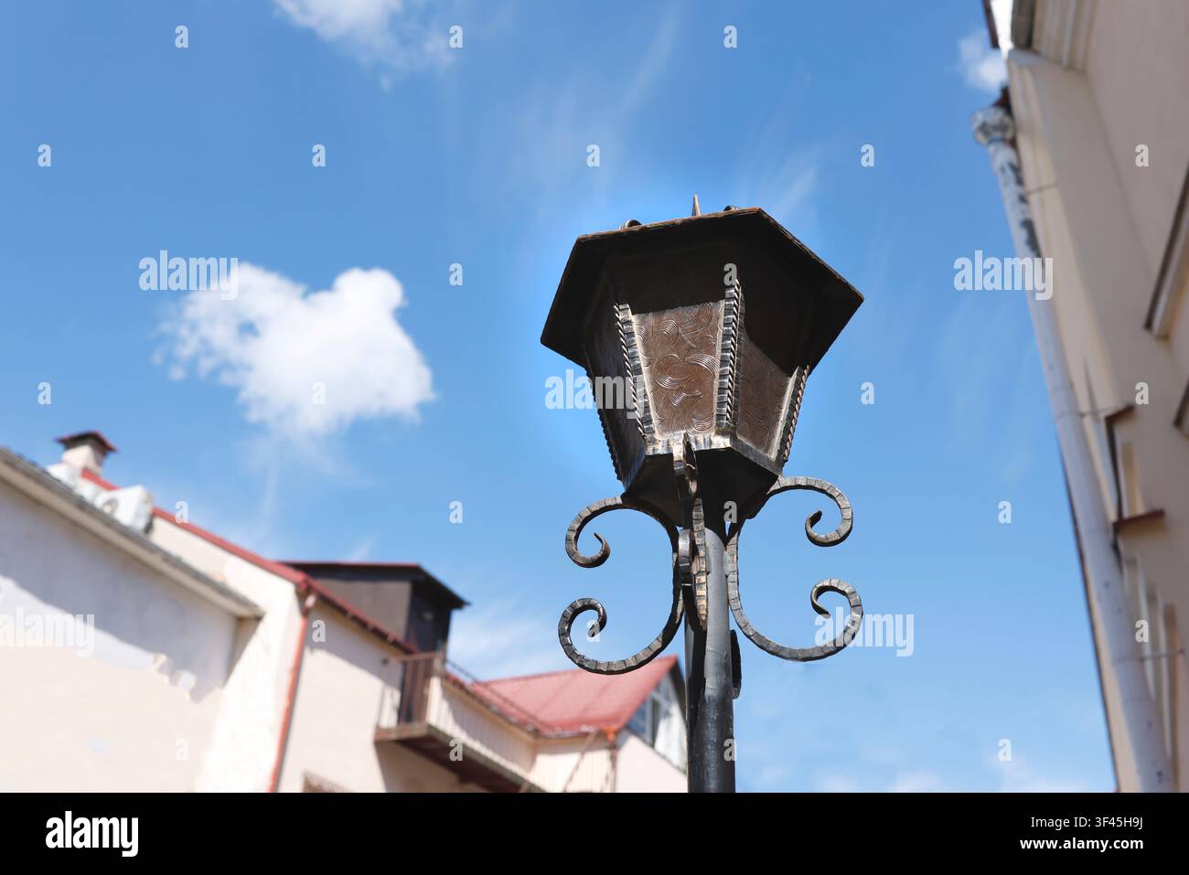 Foto di lanterna da strada vintage in ferro battuto. Lampione da esterno retrò con vetri decorati sotto un cielo azzurro. Architettura urbana classica antica Foto Stock
