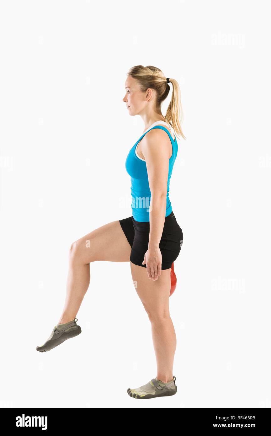Donna atletica in equilibrio su una gamba durante il fitness funzionale Foto Stock