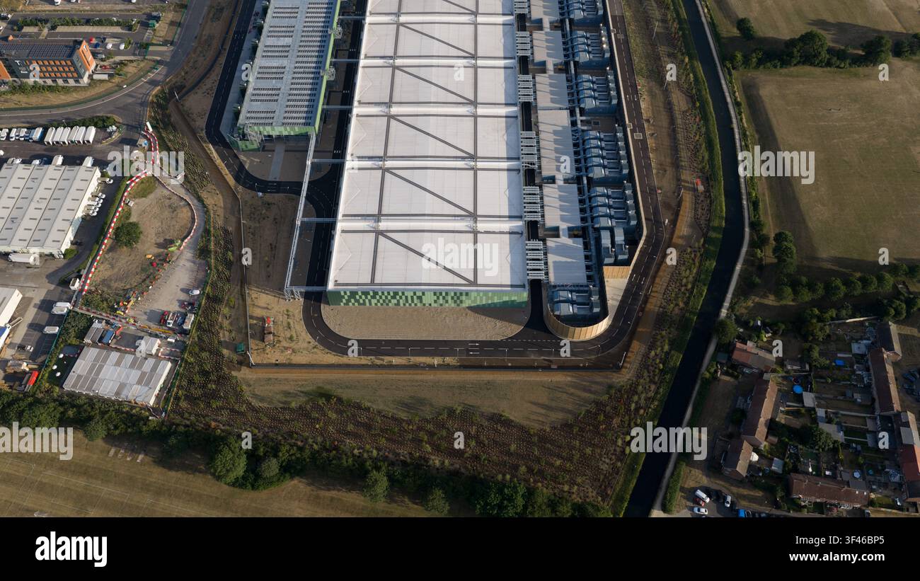 Vista aerea di un grande moderno magazzino industriale con tetto bianco, facciata verde e strade asfaltate circostanti a Waltham Cross, Inghilterra, Un Foto Stock