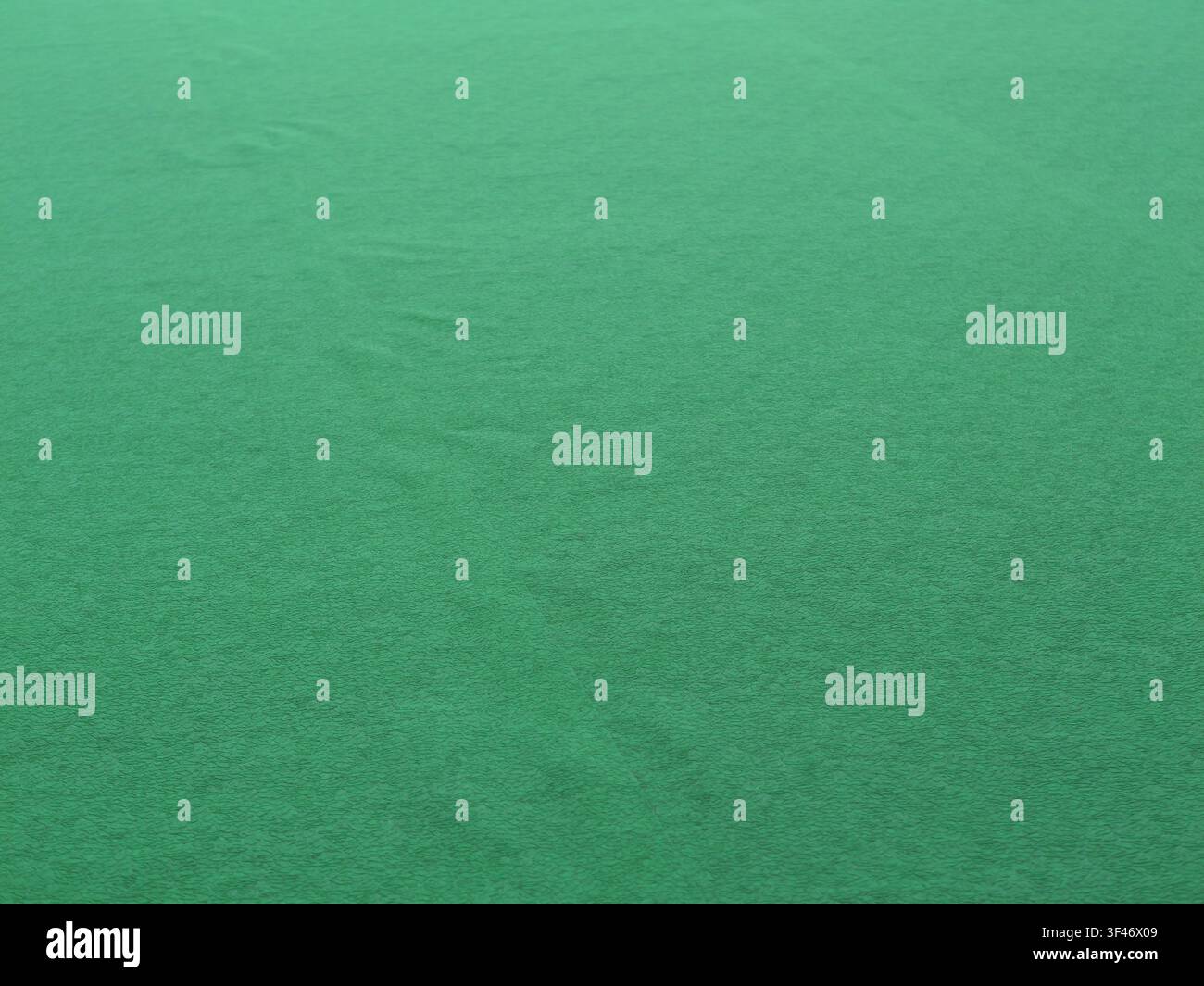 Primo piano di un tessuto di feltro verde liscio con una finitura opaca morbida e pieghe sottili, creando uno sfondo astratto e minimale Foto Stock