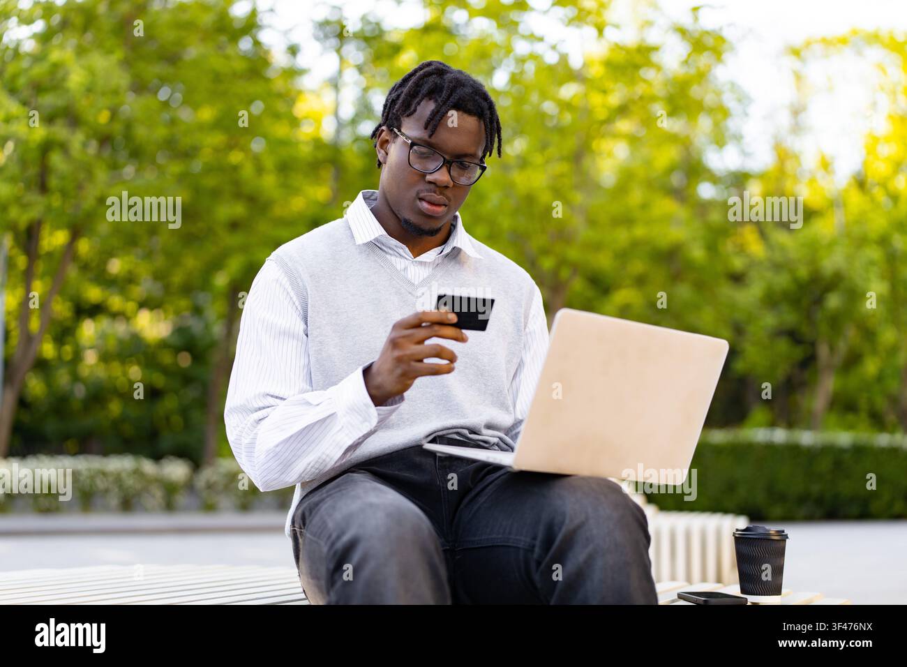 Uomo che utilizza un laptop e una carta di credito Foto Stock