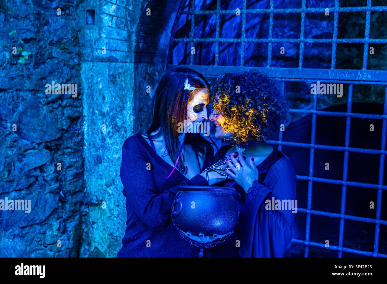 Donne che celebrano Halloween con trucco spaventoso e una pentola Foto Stock