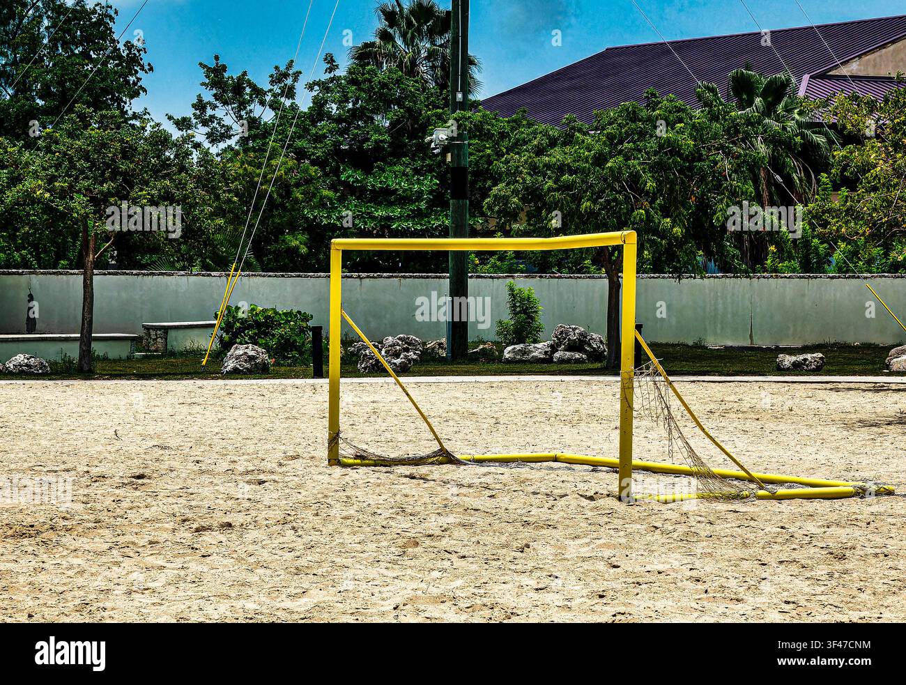 Un goal da calcio da spiaggia giallo brillante posizionato su un campo sabbioso Foto Stock