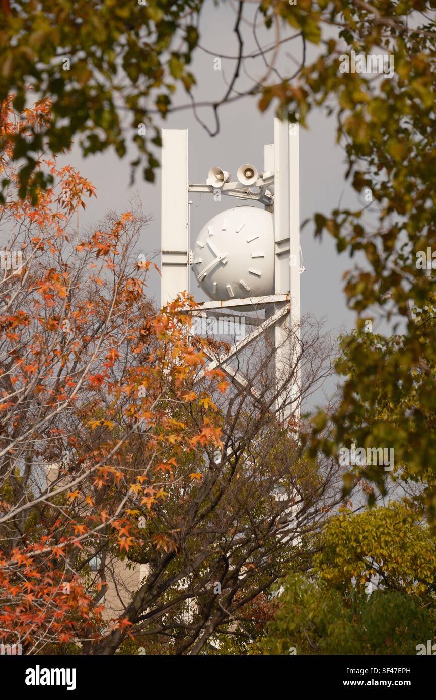 L'orologio rotondo della pace visto tra gli alberi autunnali nel Parco Memoriale della Pace di Hiroshima, Giappone. Foto Stock