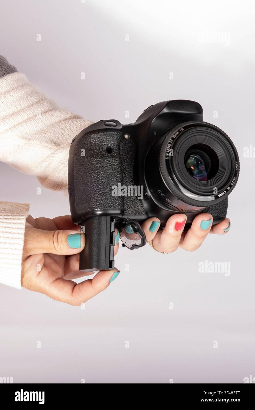Installazione di una batteria ricaricabile in una fotocamera digitale con spazio per il testo, verticale Foto Stock