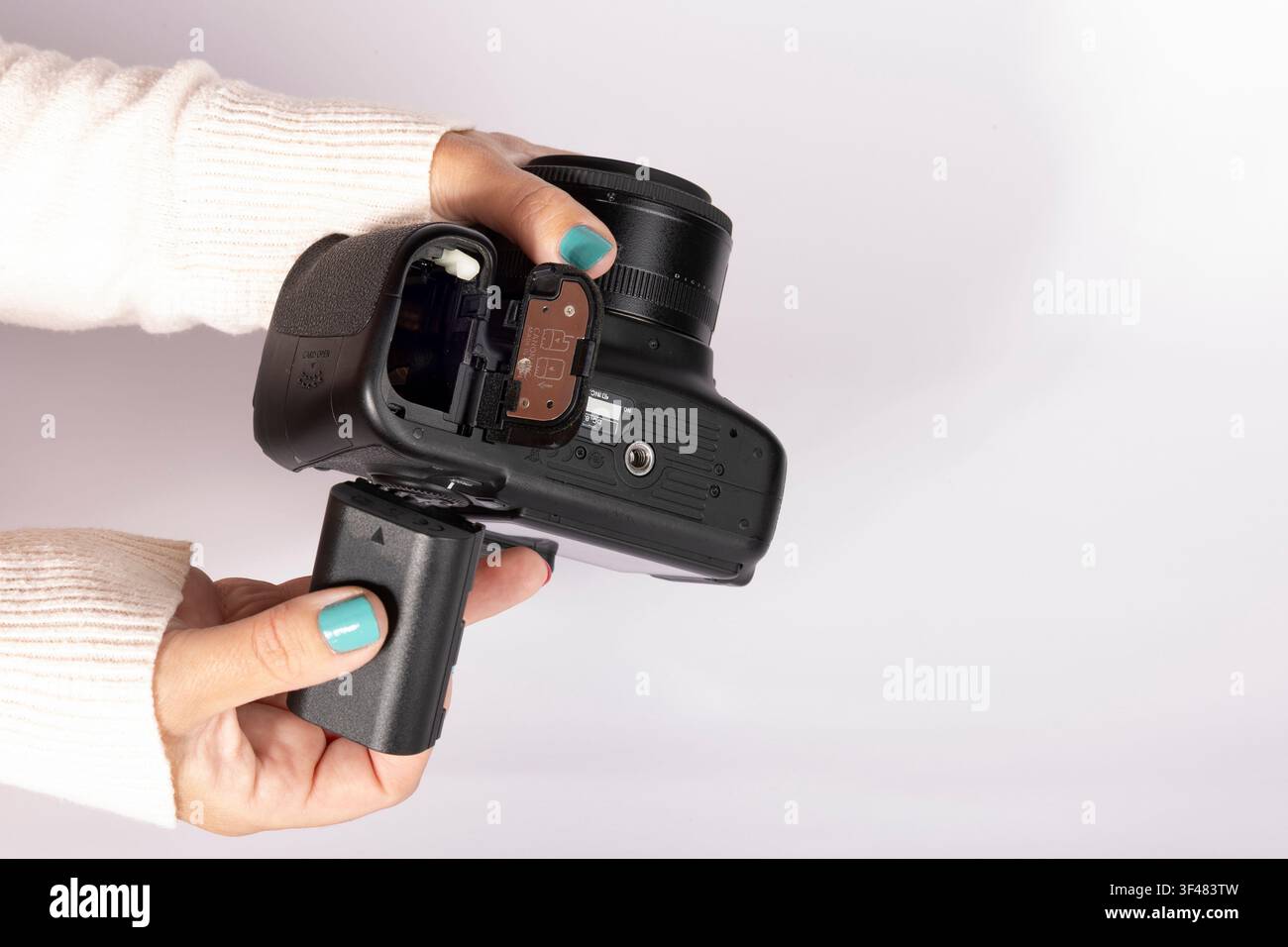 Installazione di una batteria ricaricabile in una fotocamera digitale prima di uno scatto fotografico Foto Stock