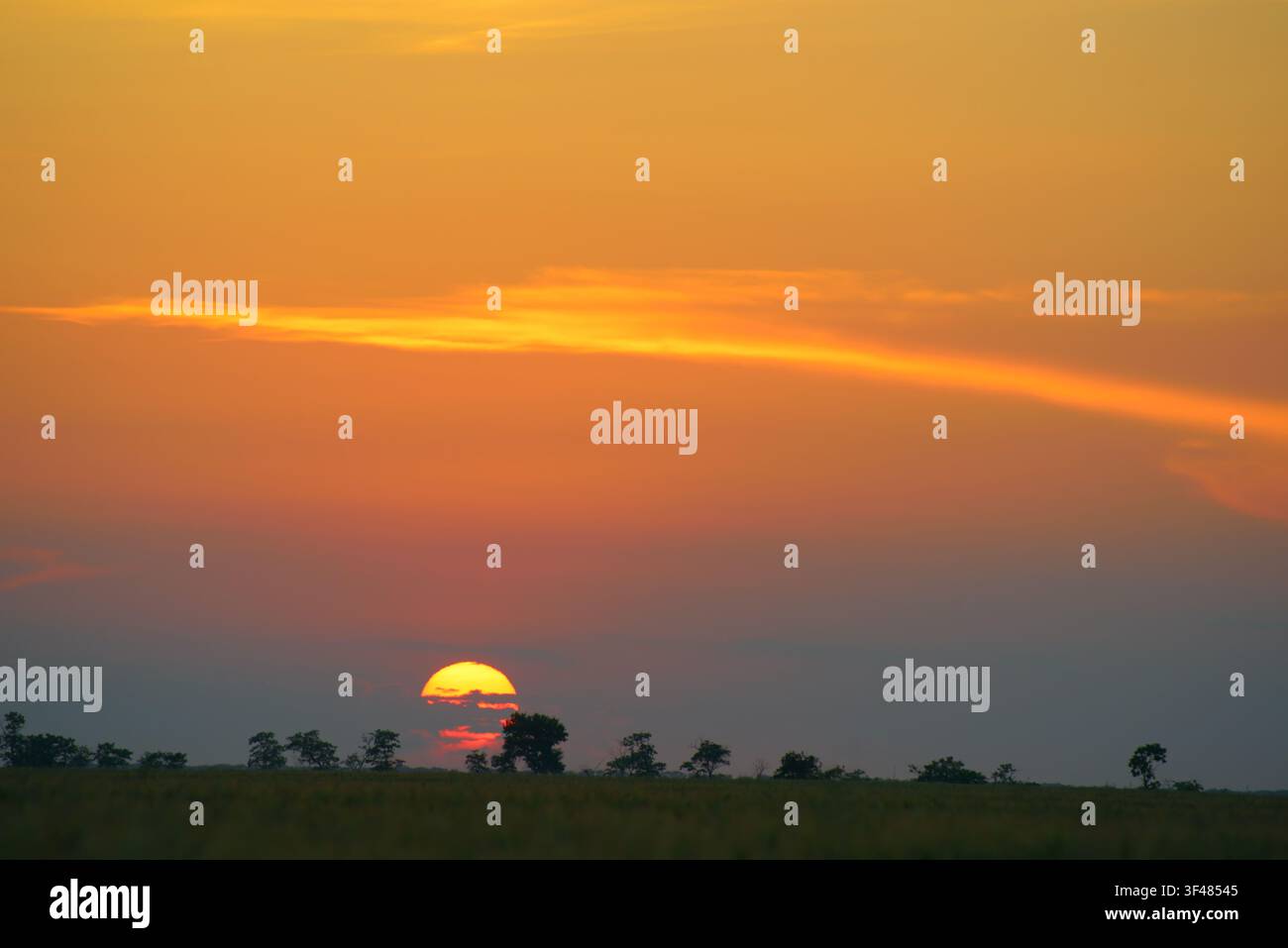 Disco solare arancione e splendido tramonto rosso sulla superficie terrestre. Foto Stock