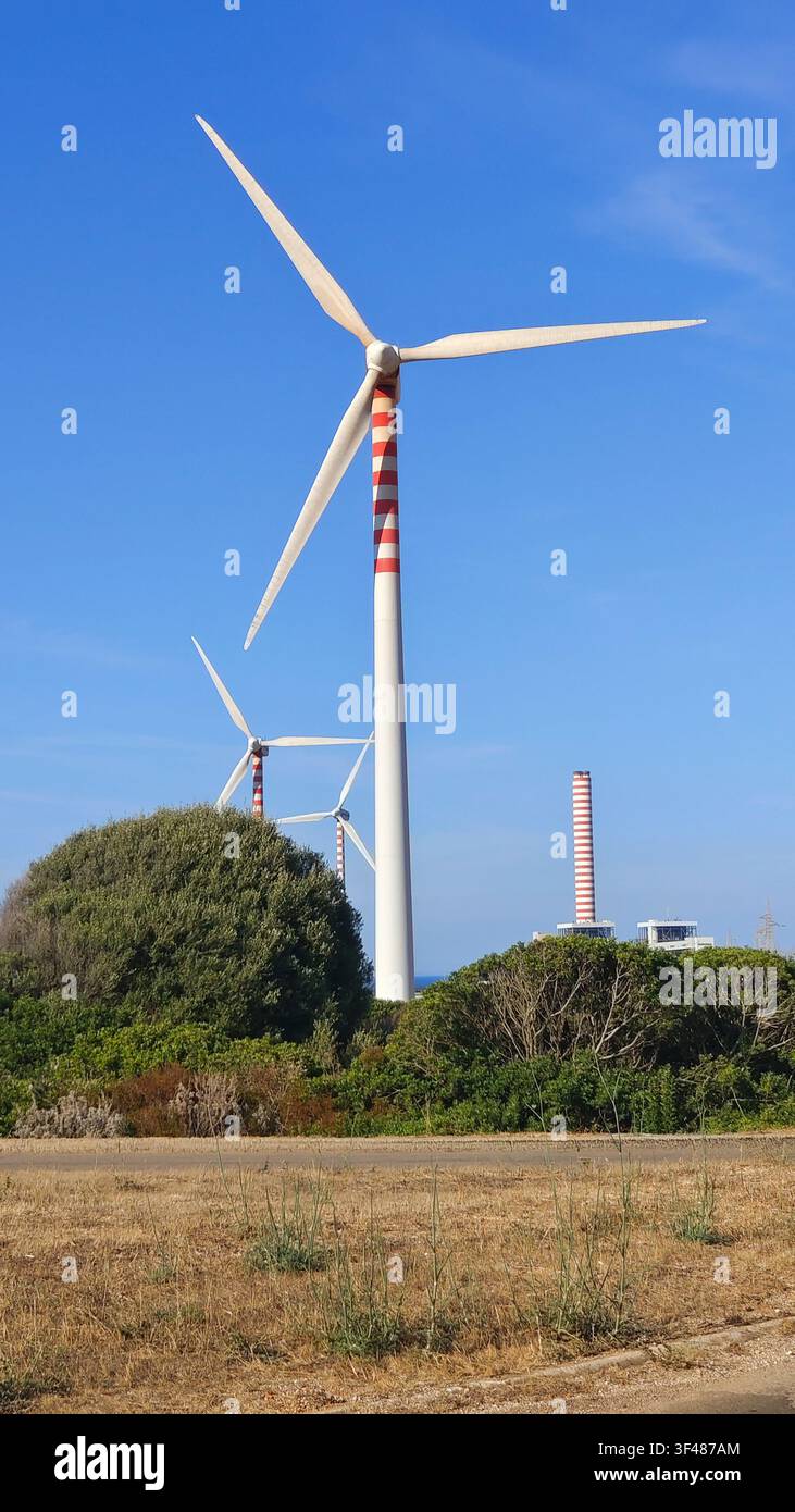 Parco eolico con più turbine che producono energia rinnovabile sotto un cielo blu limpido Foto Stock