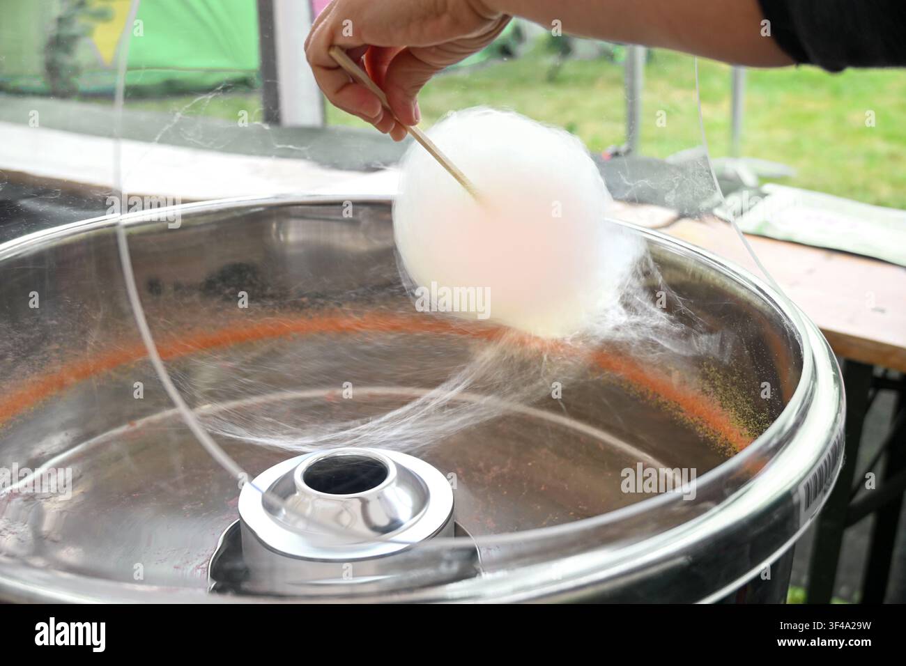 Fare zucchero filato in una pentola con centrifuga e bobina di riscaldamento, i fili vengono filati da cristalli di zucchero o isomalt e avvolti, messa a fuoco selezionata, stretto de Foto Stock
