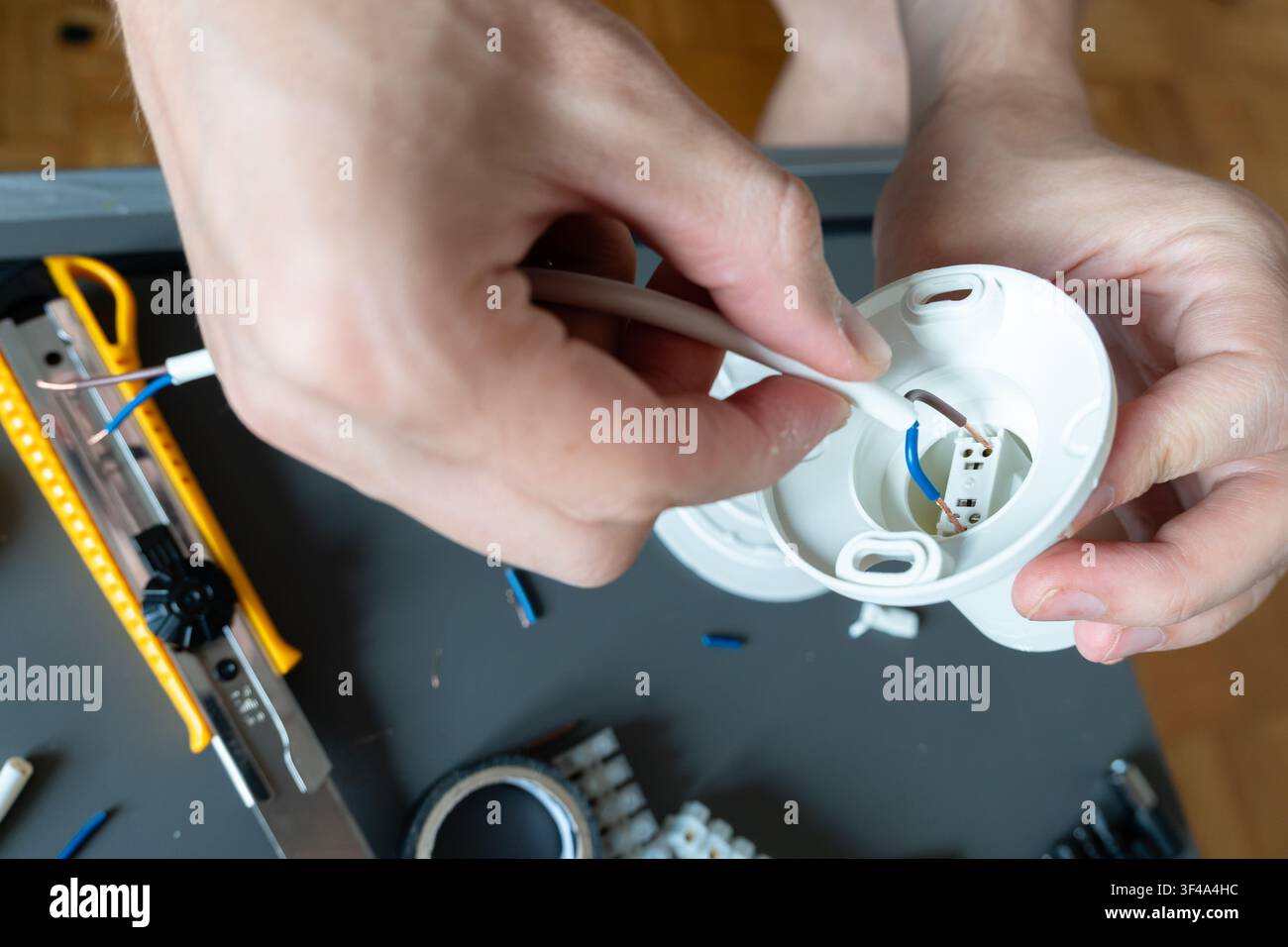 Collegamento di cavi elettrici all'interno di una base di montaggio per lampada da soffitto Foto Stock
