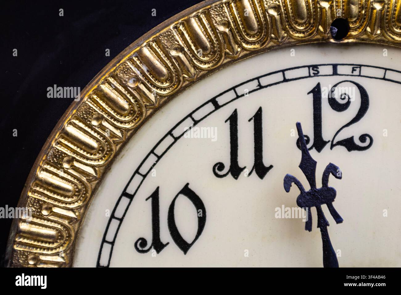 Quadrante dell'orologio... Vista ravvicinata di un quadrante vintage con bordi dorati su legno scuro. Foto Stock