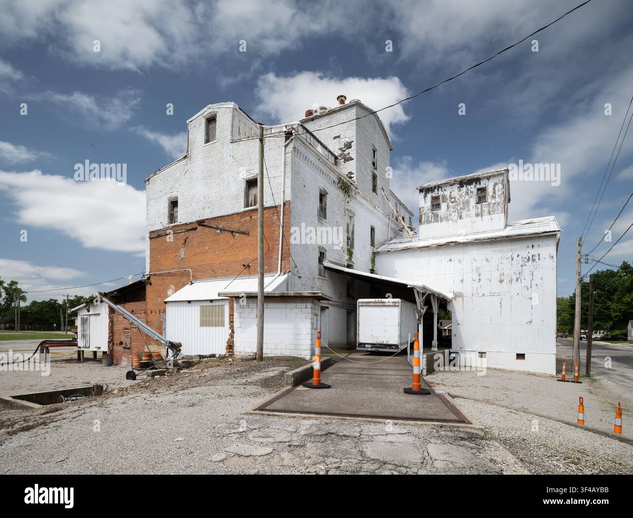 Millstadt Mill, Millstadt, Illinois, USA. Banchina di carico con un camion cassone parcheggiato sotto il riparo e il blocco del mulino in mattoni oltre. Foto Stock