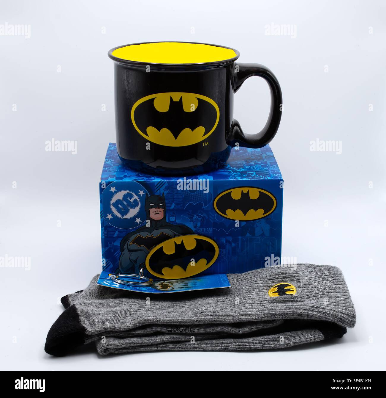 Set regalo ufficiale di Batman contenente un portachiavi, una tazza da caffè in ceramica e calzini a tema su uno sfondo bianco Foto Stock