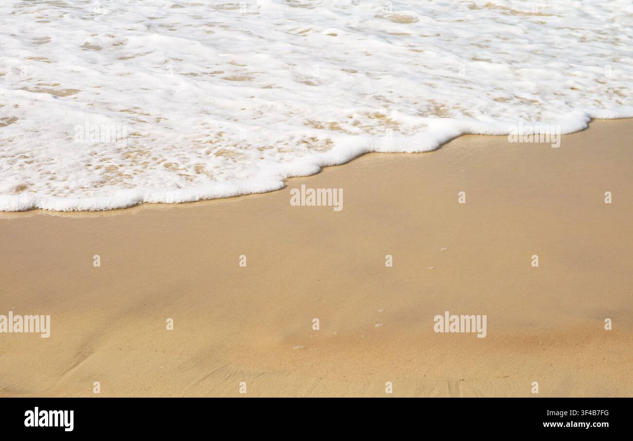 Sfondo concettuale di un'onda oceanica che si infrange su una tranquilla spiaggia sabbiosa rappresentante la consapevolezza Foto Stock