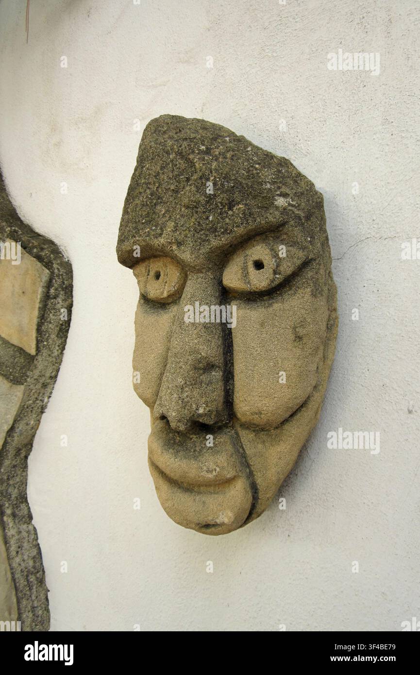 Scultura in pietra alta 50 cm, con un design a maschera antropomorfa, creata e scolpita dall'autrice della fotografia stessa. Foto Stock