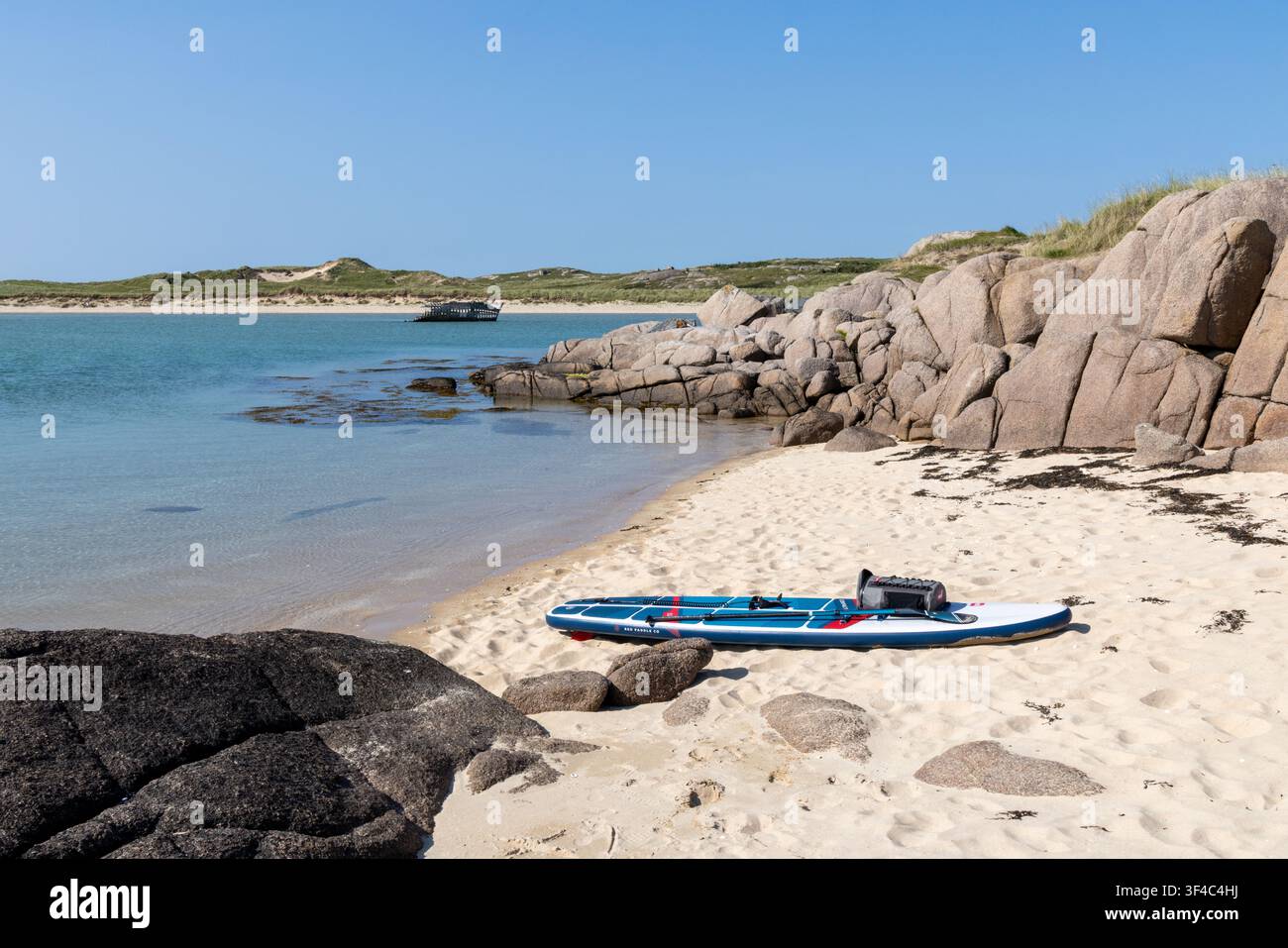 Paddleboard sull'isola della spiaggia di Bunbeg con il relitto del Bad Eddie, Donegal, Irlanda Foto Stock