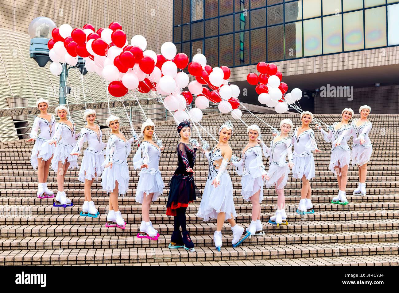 I performer degli Imperial Ice Stars in costumi de Il lago dei cigni posano con palloncini festivi sulle scale iconiche. Centro Culturale di Hong Kong, Cina. Foto Stock