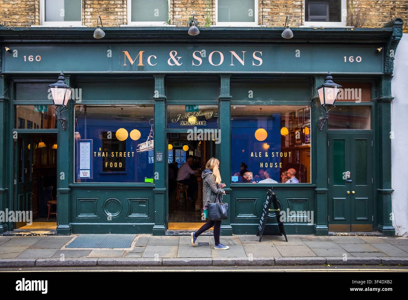 Londra, Regno Unito, 18 agosto 2025, vista di una donna che passa davanti al Mc and Sons, un pub irlandese nel quartiere di Southwark. Foto Stock