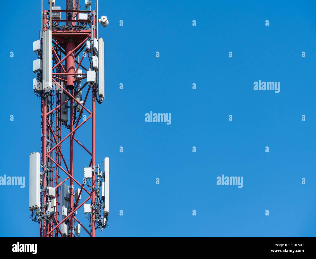 Torre di telecomunicazioni mobili per rete senza fili 5G contro un cielo blu brillante Foto Stock