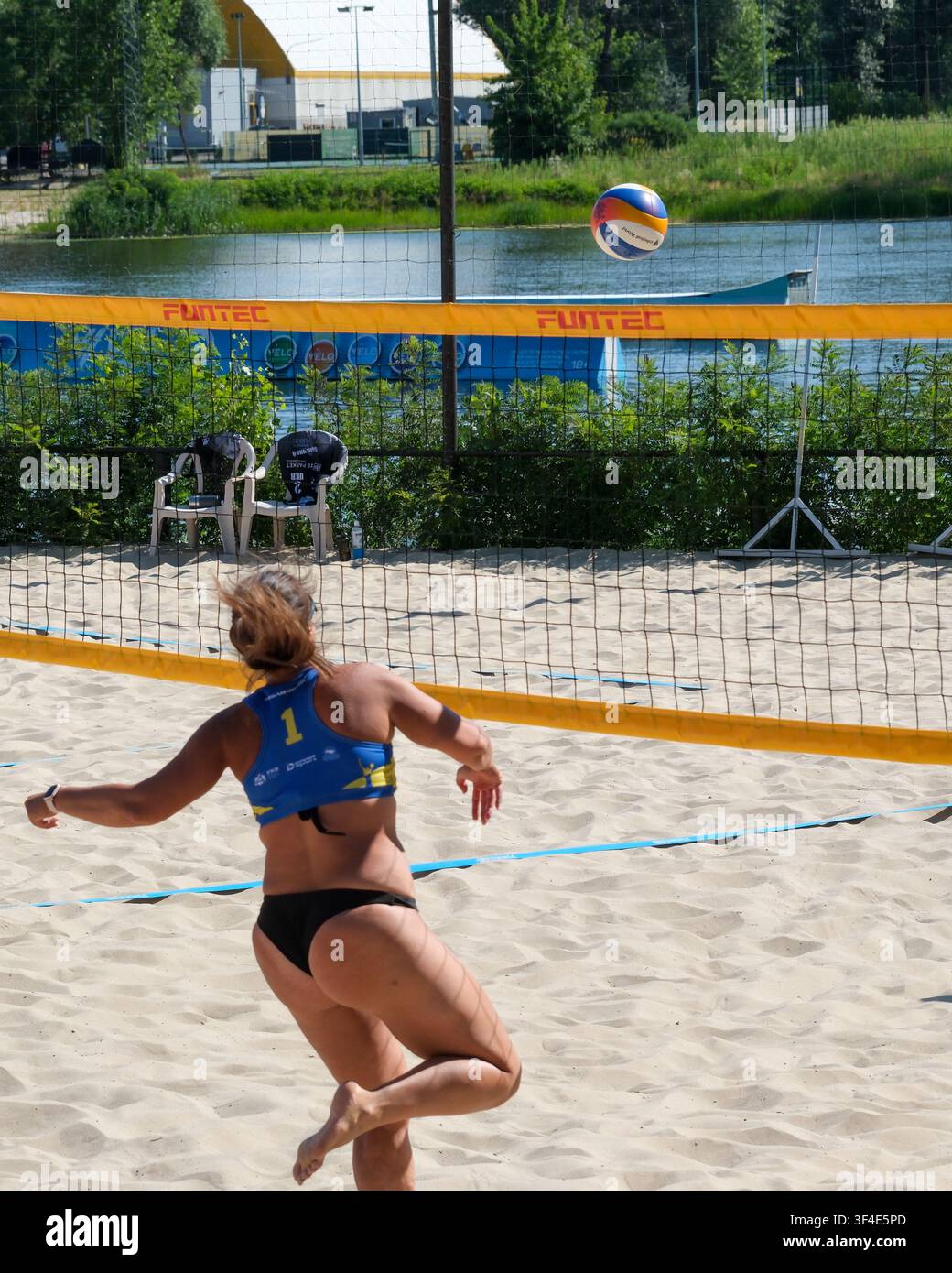 KIEV, UCRAINA – 26 LUGLIO 2026: Una giocatrice di beach volley corre sulla sabbia inseguendo la palla durante una partita all'aperto. Il berretto d'azione Foto Stock