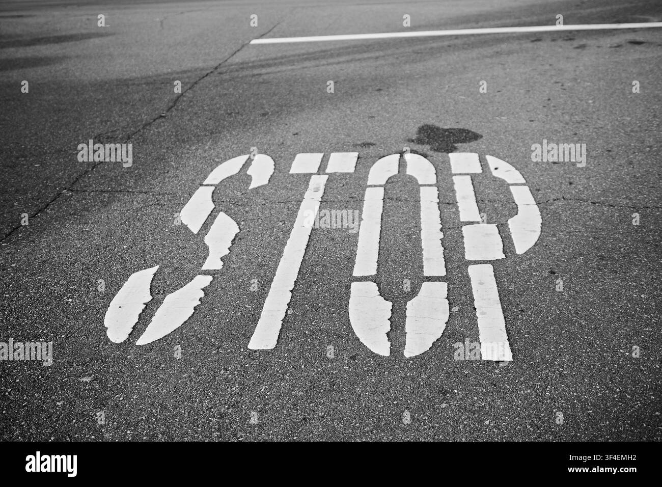 Segnaletica stradale STOP bianca dipinta sull'asfalto a Corona, California, che enfatizza il controllo del traffico, la sicurezza pubblica e i trasporti urbani. Foto Stock