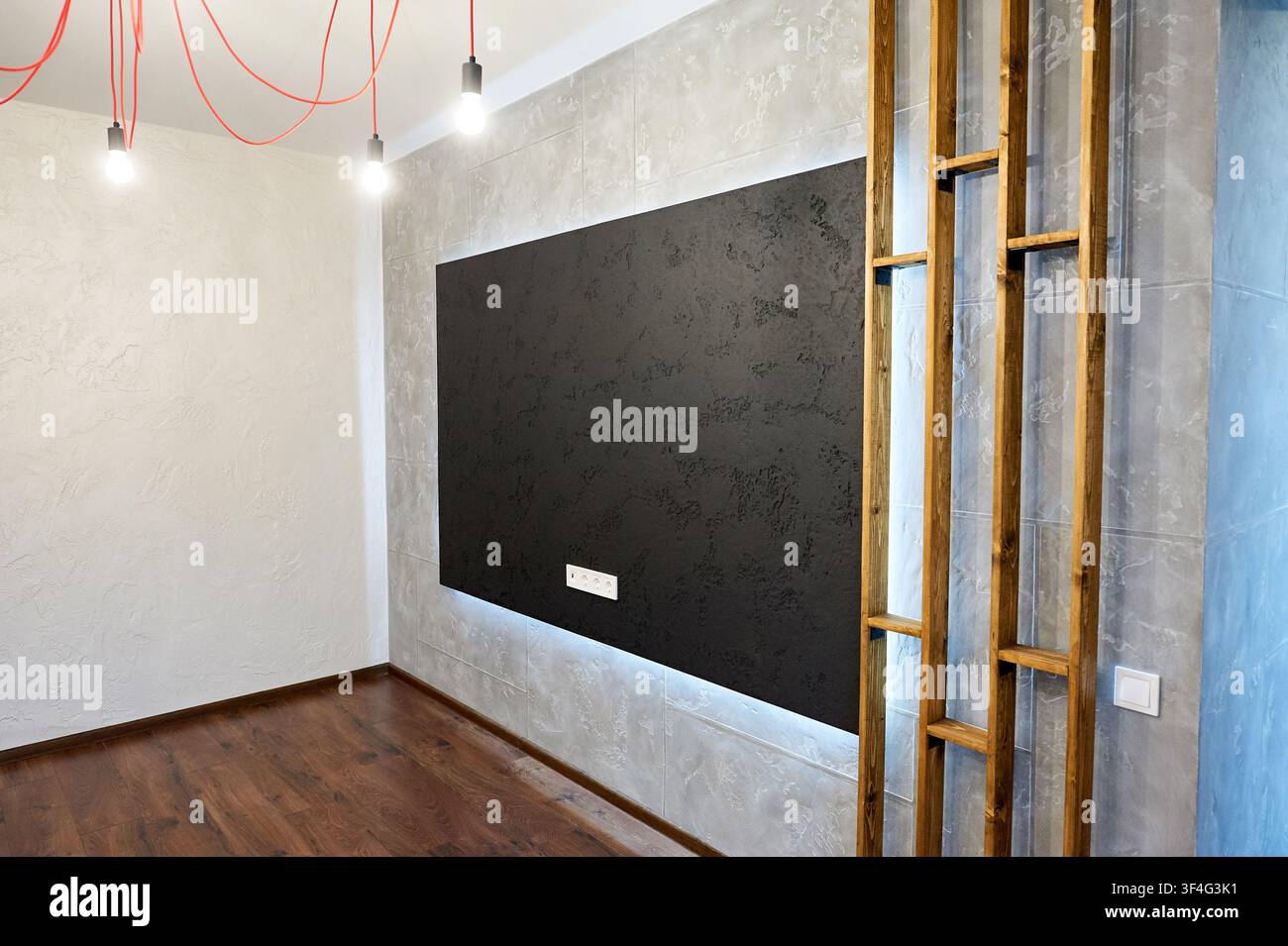 Camera di appartamento contemporaneo con parete d'accento illuminata e pavimento laminato in legno. Spazio abitativo pulito, arredamento moderno e concetto di ristrutturazione. Foto Stock