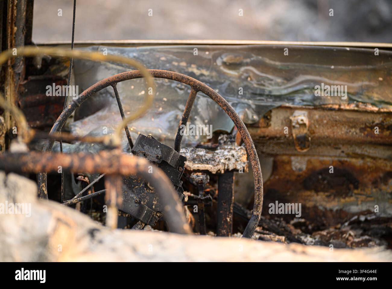 Vista interna di un'auto completamente distrutta dal fuoco con plastica fusa Foto Stock