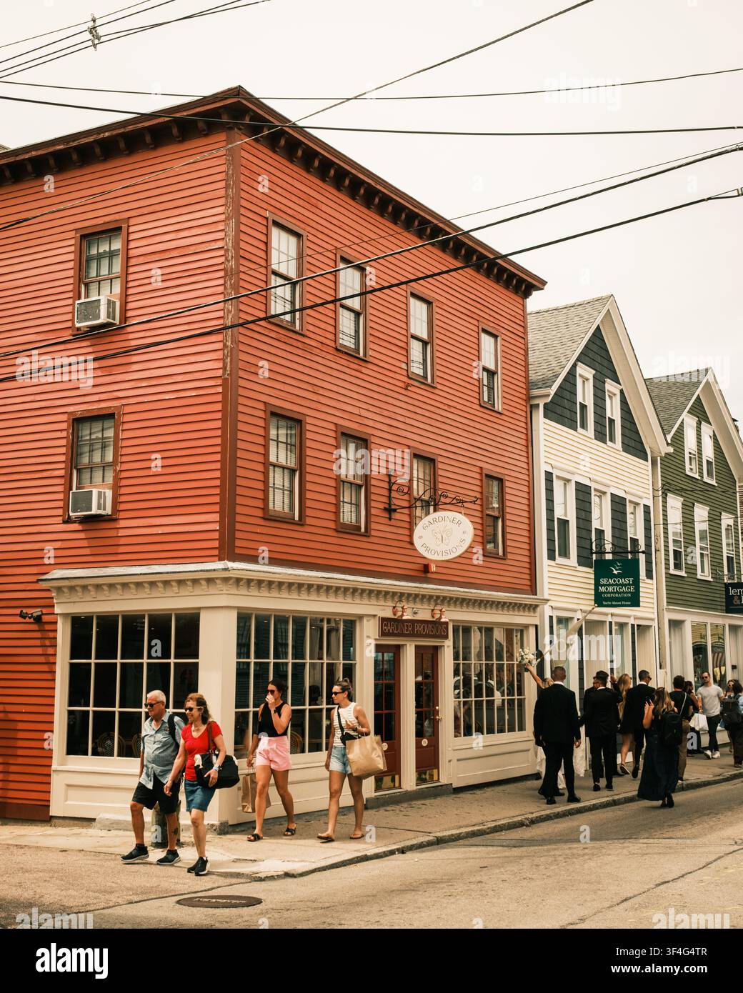 Le persone camminano lungo una strada fiancheggiata da edifici e negozi colorati a Newport, Rhode Island Foto Stock