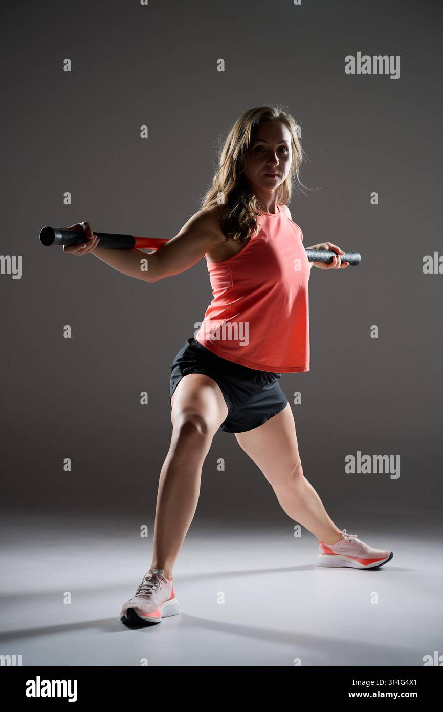 L'allenamento Stick Mobility utilizza bastoncini di resistenza flessibili per migliorare la mobilità articolare, la stabilità, la postura e la forza. Efficace per il riscaldamento, il recupero, la riabilitazione e la fitness funzionale Foto Stock