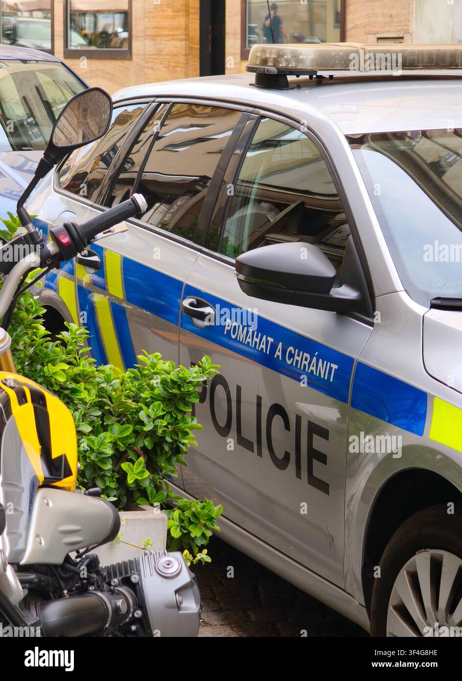 Auto della polizia ceca con il testo della targa pomahat a chranit parcheggiata su una strada cittadina - Immagine stock catturata con smartphone