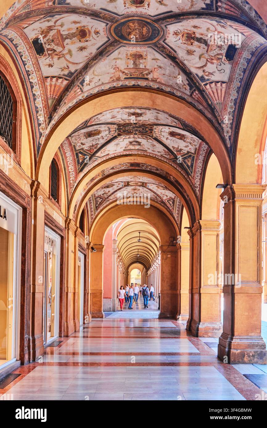 Bologna, Italia – Maggio 2026: Prospettiva svanente del portico storico di Portico di Pavaglione con soffitti affrescati e pavimento in marmo lucido Foto Stock