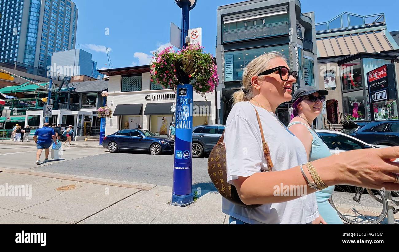 TORONTO, CANADA - 15 LUGLIO 2024: Pedoni passano davanti a negozi boutique su Bloor Street nel quartiere Yorkville di Toronto, Canada. Foto Stock