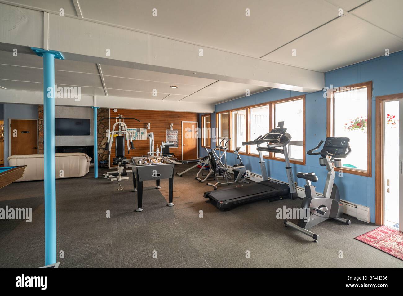 Sala fitness comunitaria con macchinari per l'esercizio e tavoli da gioco Foto Stock