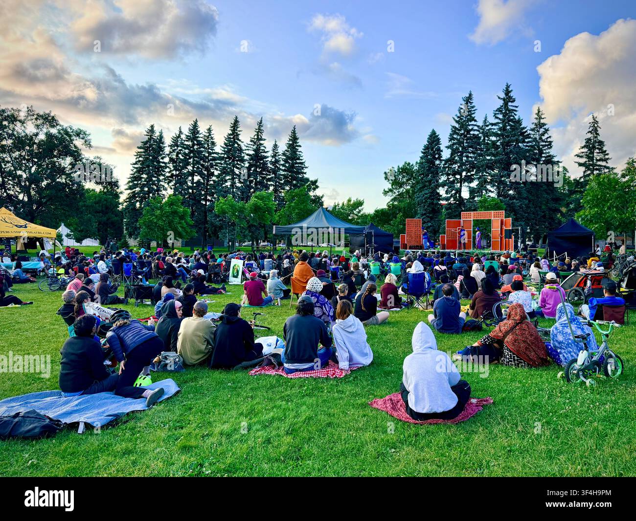 I membri del pubblico si radunano sull'erba per uno spettacolo all'aperto di Shakespeare nel parco al Jarry Park nel quartiere Villeray di Montreal, Canada - Immagine stock catturata con smartphone