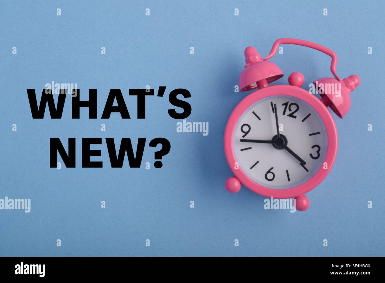 Qual è il nuovo concetto con una sveglia rosa su sfondo blu che rappresenta gli ultimi aggiornamenti, annunci, idee fresche, nuovi prodotti, tendenze e notizie Foto Stock