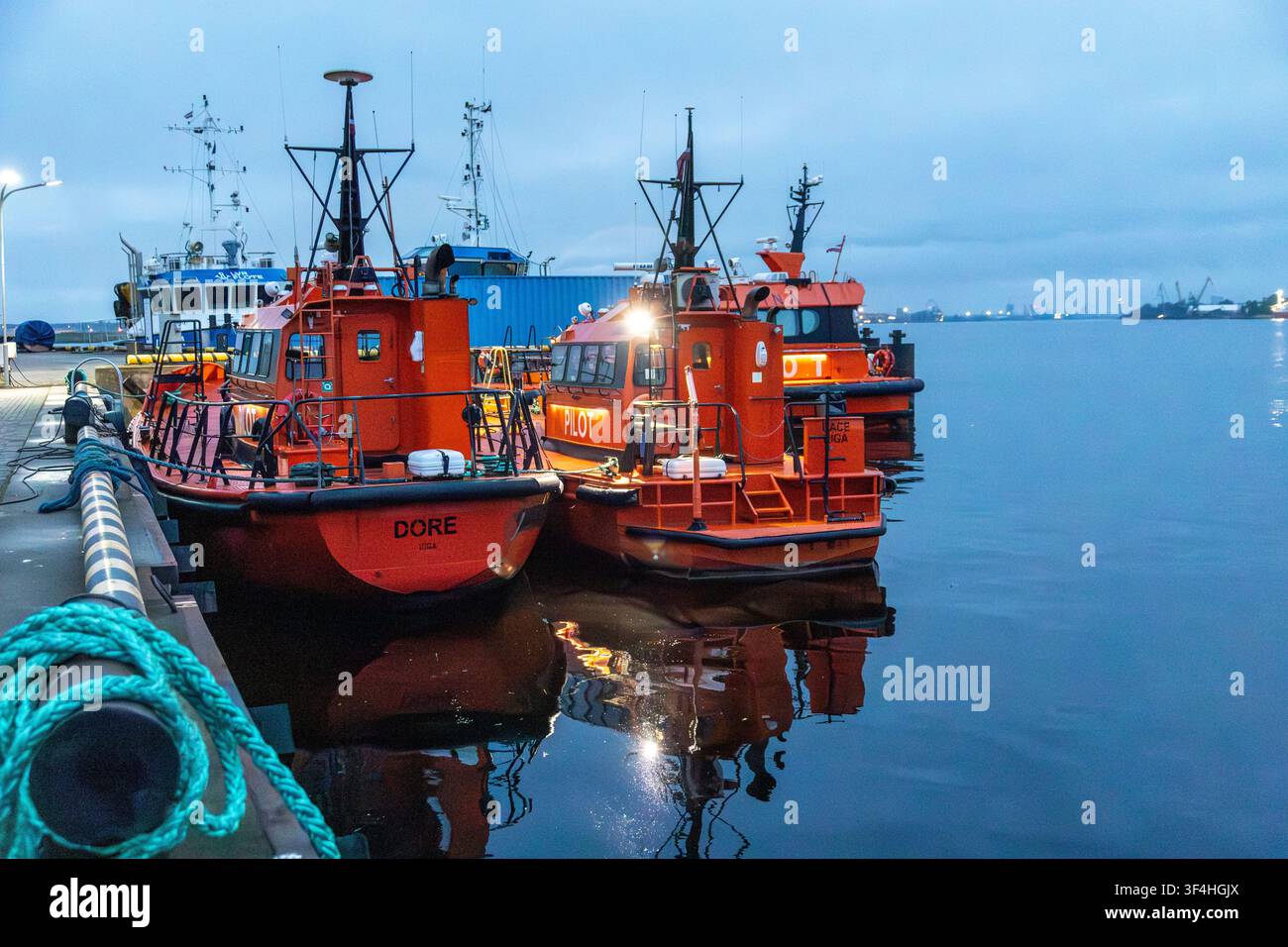 Barche pilota ormeggiate nel porto di Riga alla luce della sera, navi di servizio marittimo nel porto con riflessi sull'acqua calma. Riga, Lettonia — 22/05/2026. Foto Stock