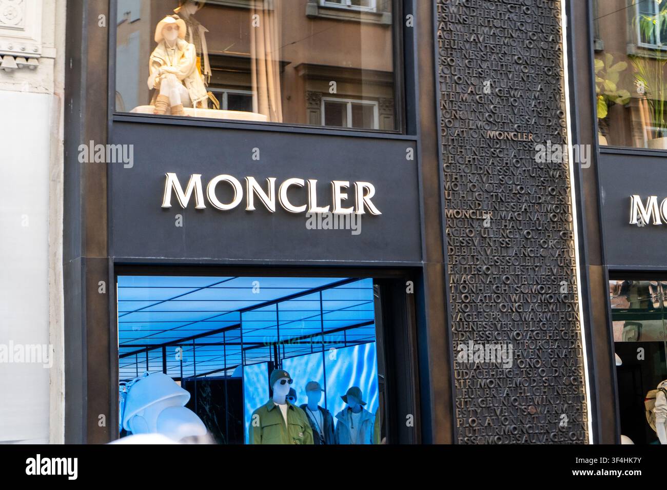 Insegna del negozio Moncler e architettura della facciata in vetro sull’esterno dell’edificio. Logo sulla vetrina della strada. Vienna, Austria - 21 giugno 2026 Foto Stock
