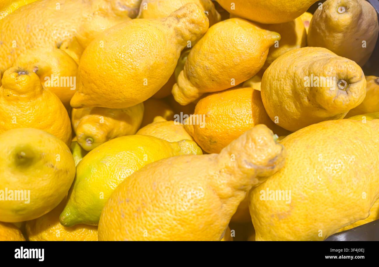 Limoni brutti in una cassa di legno su un banco di mercato. Banchi di supermercato. Foto Stock