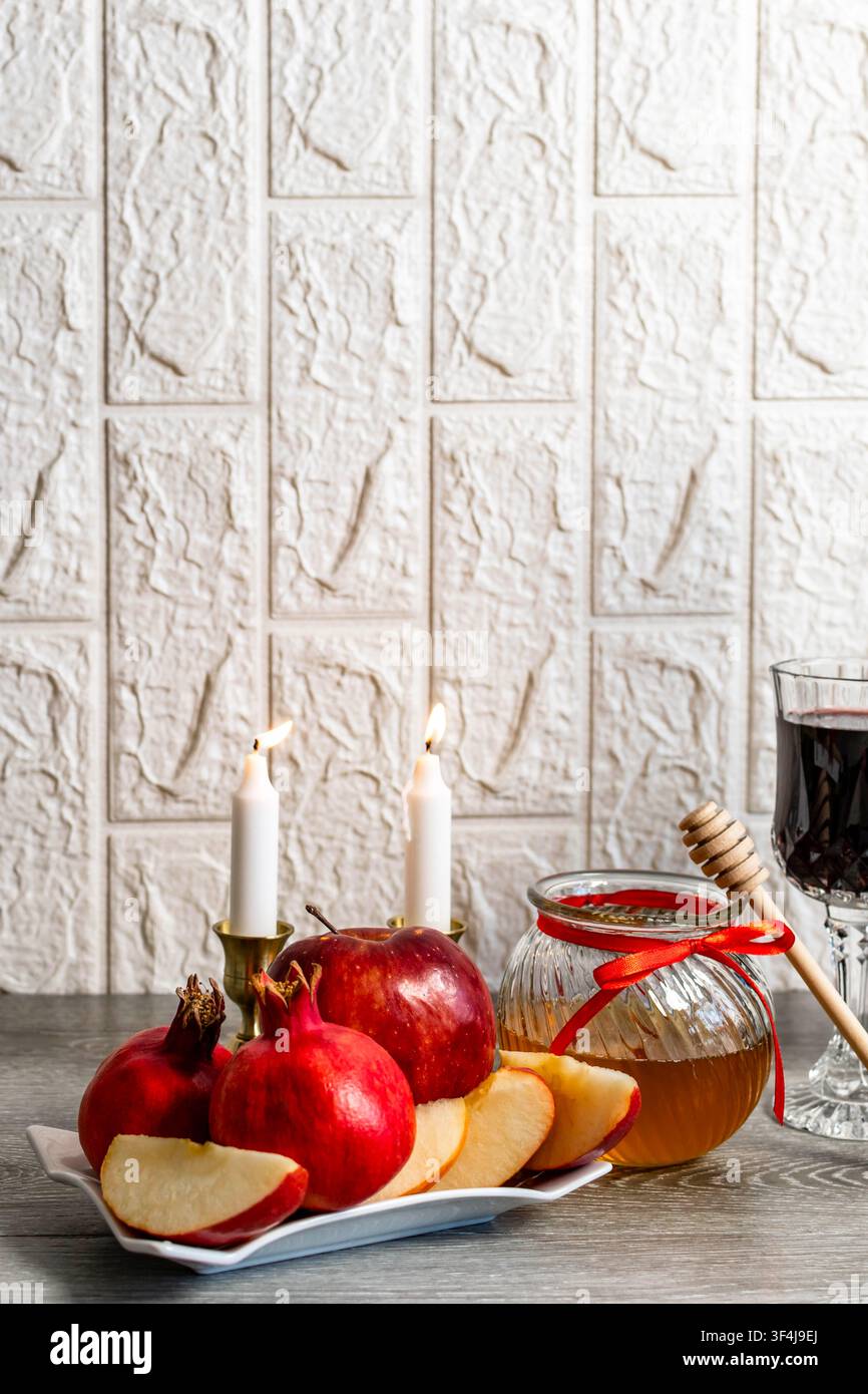 Rosh Hashanah, capodanno ebraico celebrato con cibi simbolici tradizionali e luce di candela Foto Stock