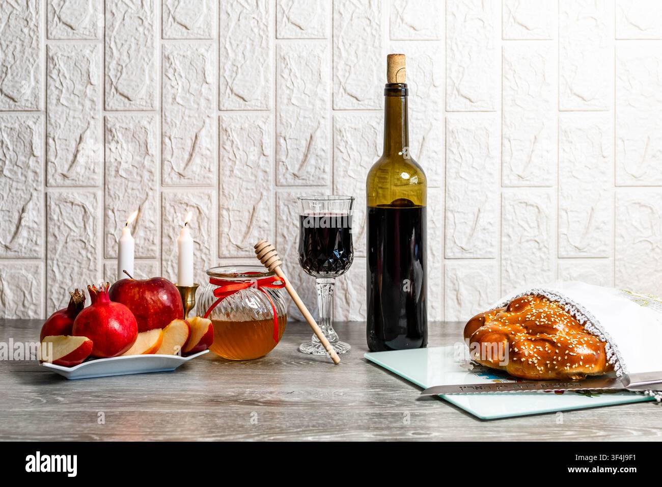 Tavolo per la celebrazione di Rosh Hashanah con cibi simbolici tradizionali e candele Foto Stock