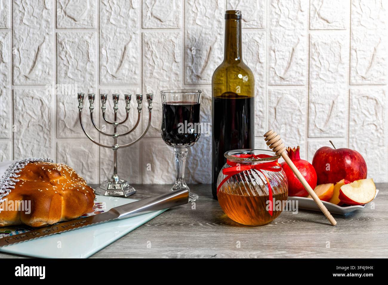 Celebrazione del nuovo anno ebraico con cibi tradizionali e menorah su un tavolo di legno Foto Stock
