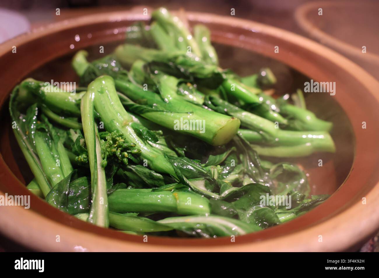 Broccolo cinese stir-fry (Gai Lan) con aglio servito in una pentola di terracotta in un ristorante, Foshan City, provincia di Guangdong in Cina Foto Stock