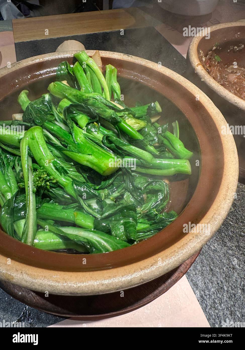 Broccolo cinese stir-fry (Gai Lan) con aglio servito in una pentola di terracotta in un ristorante, Foshan City, provincia di Guangdong in Cina Foto Stock