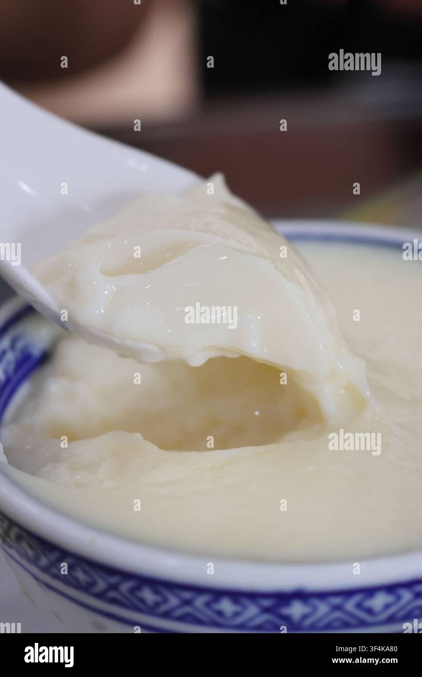 Il tradizionale budino al latte a doppia pelle (Shuāng pí nǎi) è un budino cantonese di uova al latte cotto a vapore, fatto di latte, albumi e zucchero a Foshan, Guangdong, Cina Foto Stock